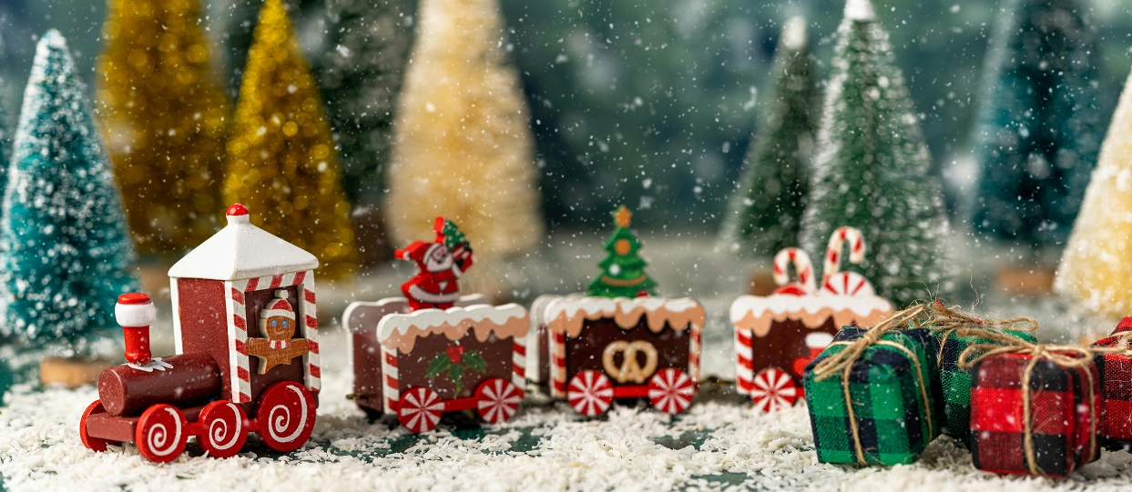 Festive toy train with snowy trees background