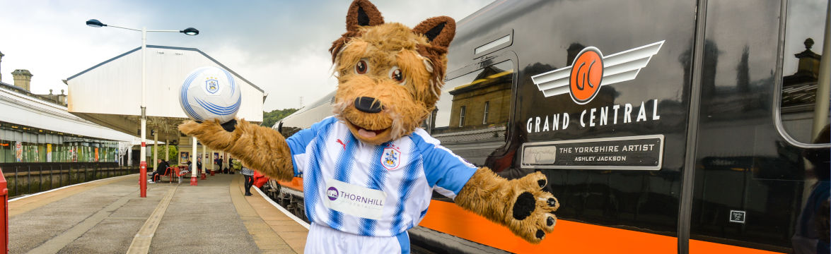 HTAFC mascot next to Grand Central train in Huddersfield